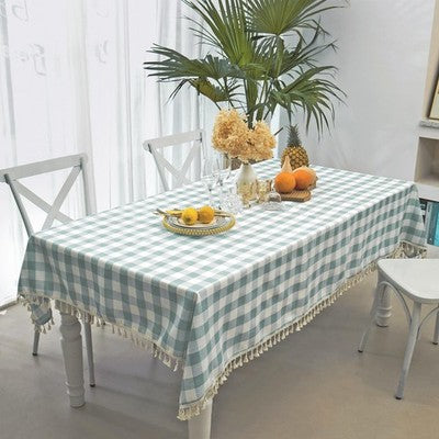 Aqua and white buffalo plaid cotton tablecloth with corner tassels on a large rectangular dining table, 55x102 inches