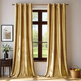 Two gold velvet blackout curtain panels 52x84 inches with silver grommets hanging on a rod in a living room