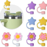 Eight hot pink star-shaped silicone straw covers displayed near Stanley tumblers, dust-proof reusable straw toppers