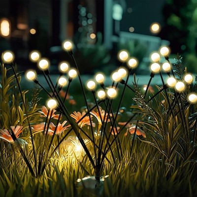 Four Siuholi solar firefly starburst stake lights with warm white LEDs glowing in a garden at night