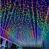 HISHINY 32ft multicolor LED icicle Christmas lights with 72 hanging drops displayed outdoors on roofline at night - view 3