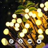 Four Siuholi solar firefly starburst stake lights with warm white LEDs glowing in a garden at night - view 5