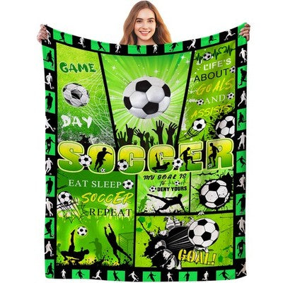 Green flannel throw blanket 60x80 inches with all-over soccer ball print, folded on a sofa, soft anti-pill fabric