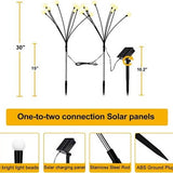Four Siuholi solar firefly starburst stake lights with warm white LEDs glowing in a garden at night - view 2