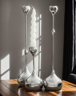 Set of 3 polished silver aluminum taper candle holders 13.78 inches tall arranged as a modern table centerpiece