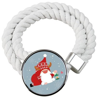 Two white cotton rope curtain tiebacks with handmade Santa Claus patterns, laid flat on a holiday-decorated surface