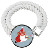 Two white cotton rope curtain tiebacks with handmade Santa Claus patterns, laid flat on a holiday-decorated surface