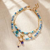 IQIC two-layer boho beaded necklace with cowrie shell and starfish charms, blue beads and gold-tone accents on white background - view 7