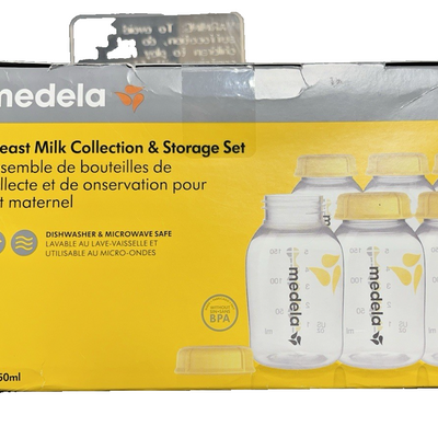 Six Medela 5oz clear breast milk storage bottles with yellow lids showing ounce and milliliter measurement markers