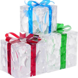 Three lit Christmas gift boxes in small, medium, and large sizes with red, green, and blue bows glowing with warm LED lights - view 4