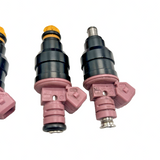 Set of 6 Bosch OEM cross-reference 0280150440 fuel injectors in mixed condition, including 4 new units, laid on surface - view 2