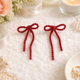 Silver bow-shaped clip-on dangle earrings with round clear CZ rhinestones on white background - view 7