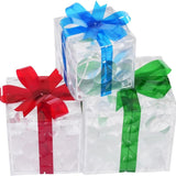 Three lit Christmas gift boxes in small, medium, and large sizes with red, green, and blue bows glowing with warm LED lights - view 3