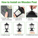 Two matte black solar post cap lights with glass shades mounted on 4x4 wood fence posts glowing warm white LED light - view 7