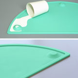 Teal oval silicone placemat 20x11 inches with raised edges and suction cups on a dining table surface - view 5