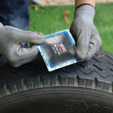 Eight black square PAX 100x100mm natural rubber tire repair patches laid flat, showing nylon ply surface and PET film backing - view 6