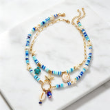 IQIC two-layer boho beaded necklace with cowrie shell and starfish charms, blue beads and gold-tone accents on white background - view 8