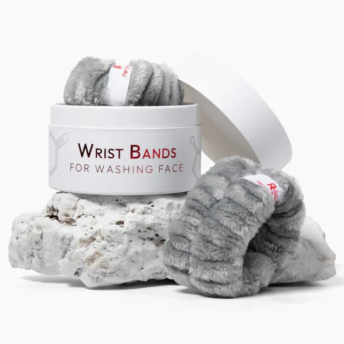Two gray fluffy flannel spa wristbands laid flat, designed to absorb water during skincare and face washing routines