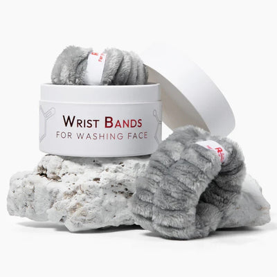 Two gray fluffy flannel spa wristbands laid flat, designed to absorb water during skincare and face washing routines