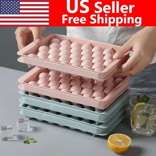 Two round sphere ice ball maker trays with lids in pink and blue BPA-free plastic for whiskey and cocktails