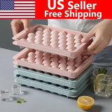 Two round sphere ice ball maker trays with lids in pink and blue BPA-free plastic for whiskey and cocktails