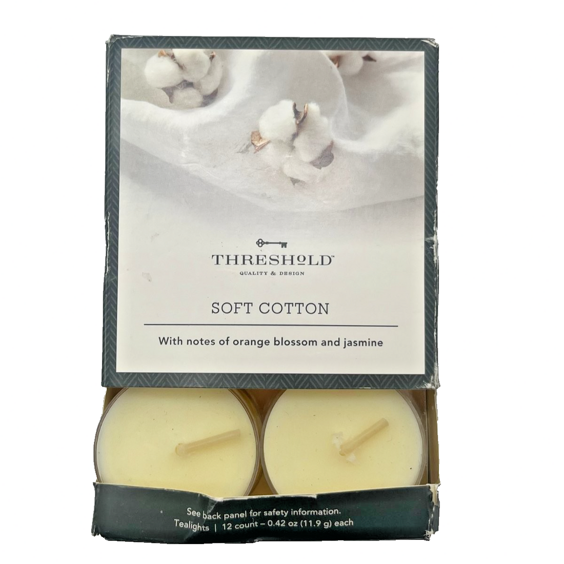 12 white Threshold tealight candles in plastic cups with orange jasmine soft cotton scent, shown in original packaging