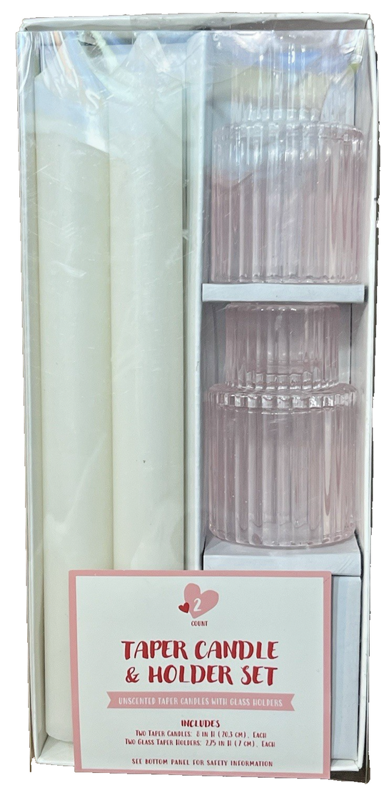 Two white 8-inch unscented taper candles standing in two translucent pink ribbed glass holders on a table