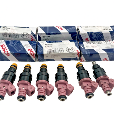 Set of 6 Bosch OEM cross-reference 0280150440 fuel injectors in mixed condition, including 4 new units, laid on surface