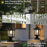 Two matte black solar post cap lights with glass shades mounted on 4x4 wood fence posts glowing warm white LED light - view 3