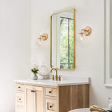 Gold metal wall sconce with handblown seeded globe glass shade 5.5 inch diameter mounted on wall, warm ambient light - view 6