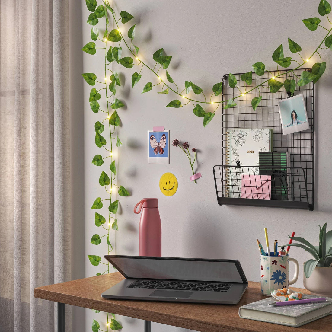 Room Essentials LED vine string lights with faux green leaves and 20 warm white bulbs draped on a shelf indoors
