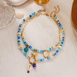 IQIC two-layer boho beaded necklace with cowrie shell and starfish charms, blue beads and gold-tone accents on white background - view 5