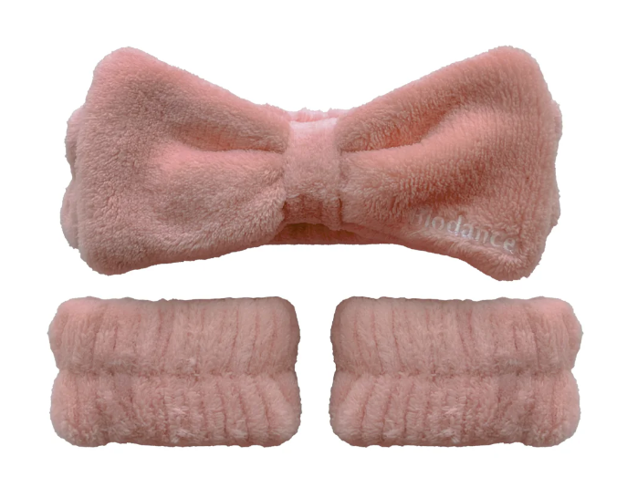 Biodance pink fluffy plush spa headband and two wristbands laid flat, elastic bow-style skincare accessory set