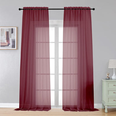 Pair of burgundy sheer voile rod pocket curtain panels 40x108 inches hanging on a window, LeCloud