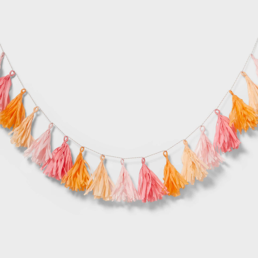 Pink and orange paper tassel party garland 60 inches wide hanging as festive birthday decoration by Spritz