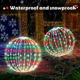 Two 16-inch multicolor LED Christmas ball sphere lights with stainless steel frame glowing outdoors in a yard at night - view 5