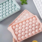 Two round sphere ice ball maker trays with lids in pink and blue BPA-free plastic for whiskey and cocktails - view 2