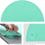 Teal oval silicone placemat 20x11 inches with raised edges and suction cups on a dining table surface - view 3