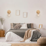 Gold metal wall sconce with handblown seeded globe glass shade 5.5 inch diameter mounted on wall, warm ambient light - view 2