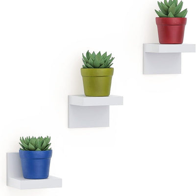 Three white L-shaped small floating wall shelves mounted on wall displaying small decor items, 4-inch plastic ledge set