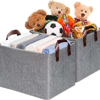Two grey collapsible fabric storage bins with leather handles and steel frame standing upright on a closet shelf